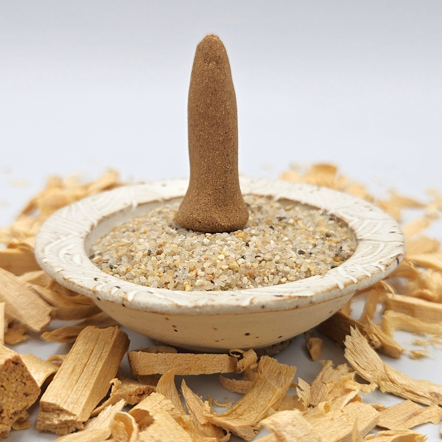 Palo Santo organic incense cone in an incense holder.